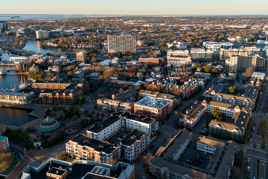 An aerial view of Norfolk, Virginia, showing the transition from cozy residential neighborhoods to a taller city skyline